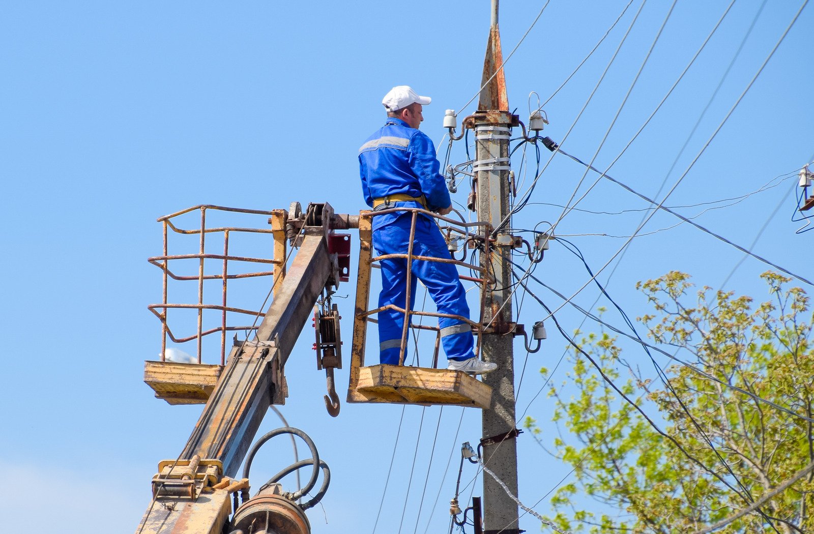 image of man in cherry picker fixing electricity power lines